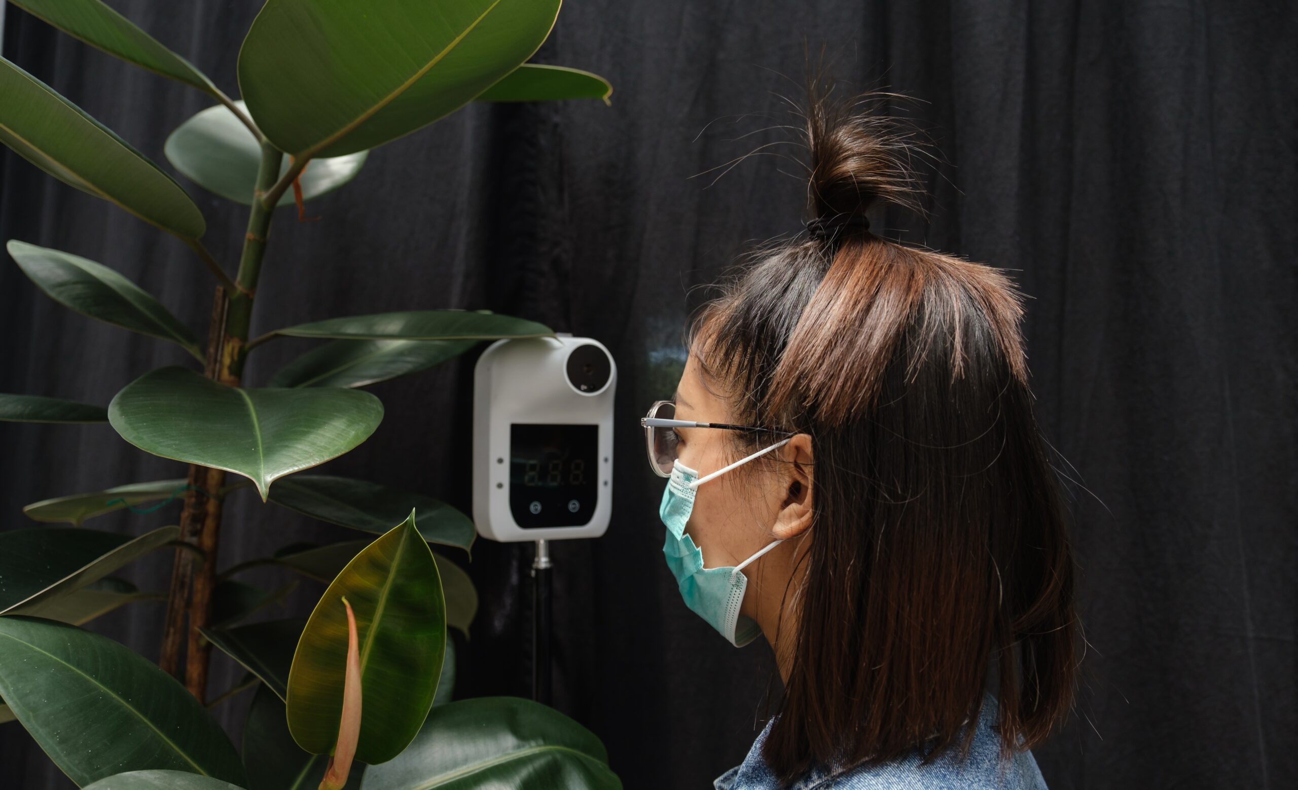 The Asian tourist woman has checked body temperature with a thermal Temperature scanner detector, new normal and travel safety concept.